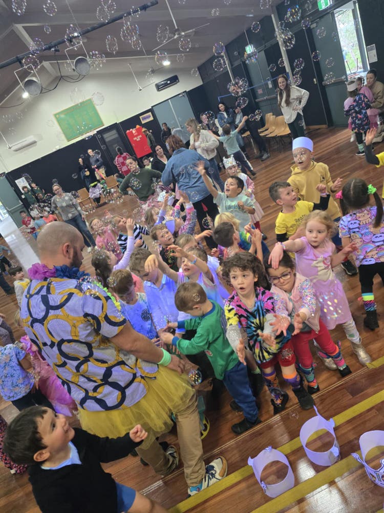 students-dressed-in-bright-colours-dancing-in-the-hall