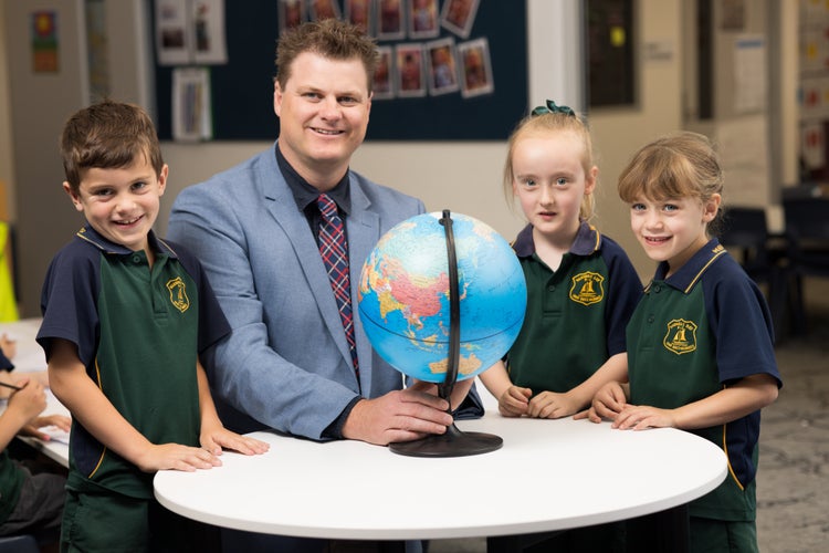 mr-lewis-with-three-students-and-a-world-globe