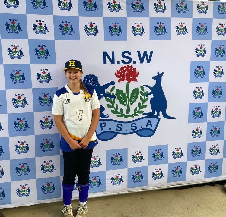 student-standing-in-front-of-nsw-banner